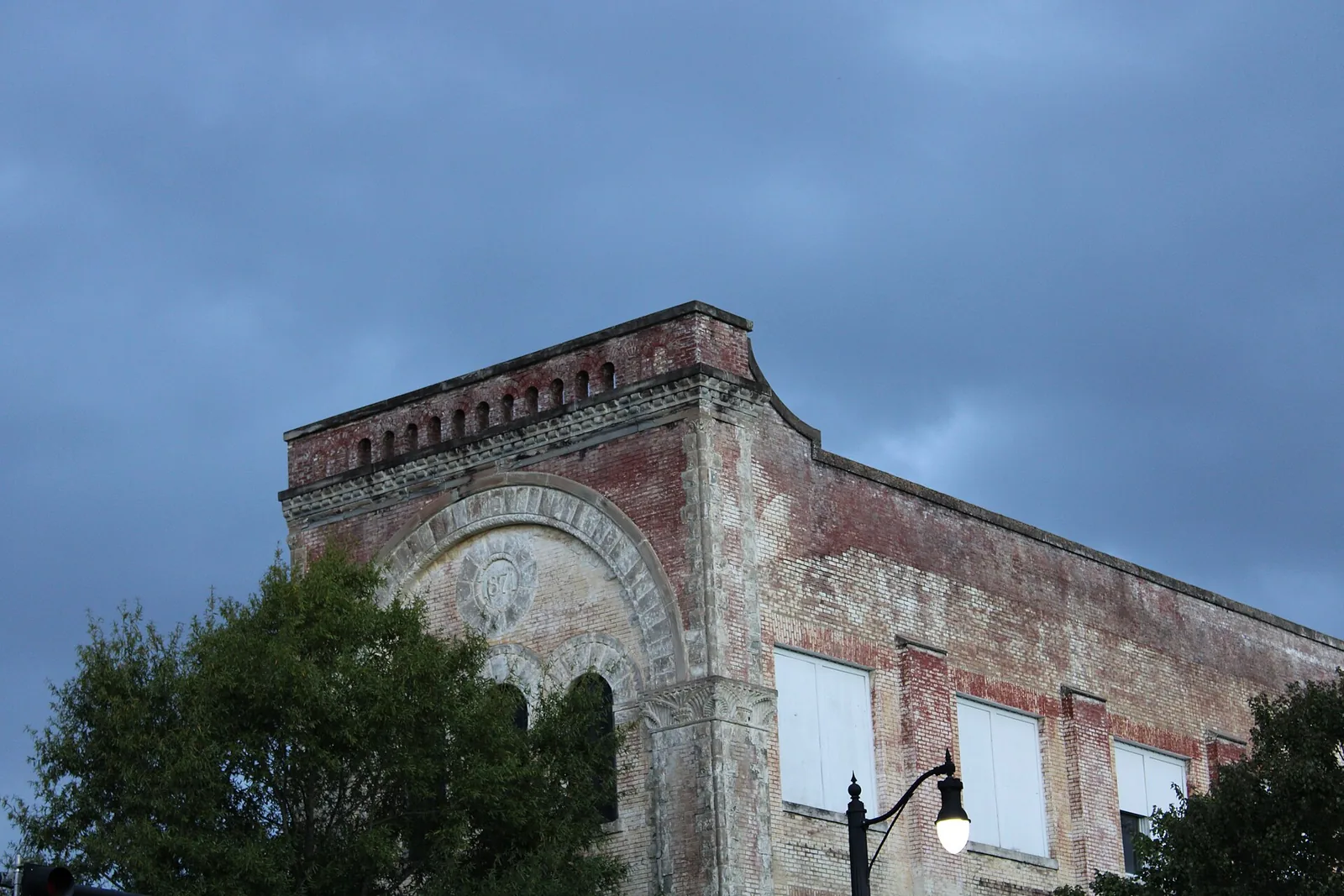A street lamp glows at dusk below the upper floors of the building that houses DePalma's Italian restaurant in downtown Tuscaloosa, the district that hosts the Tinsel Trail.