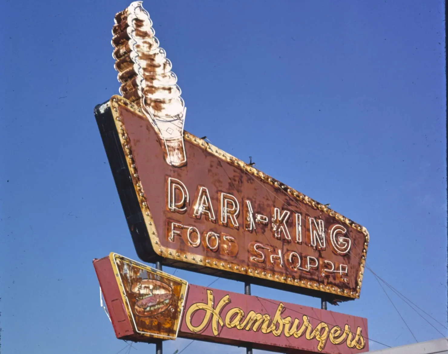 The neon soft-serve cone sign of the Dari-King Food Shoppe on Bridge Street in Tuscaloosa, photographed by John Margolies.