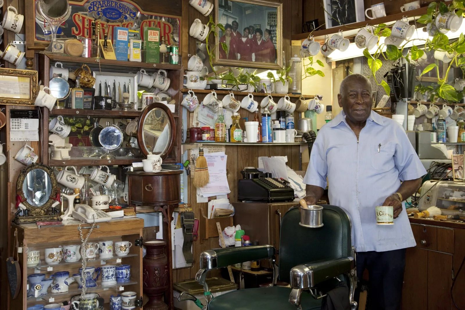Rev. Thomas Linton with his shaving mug collection inside his barbershop in Tuscaloosa.