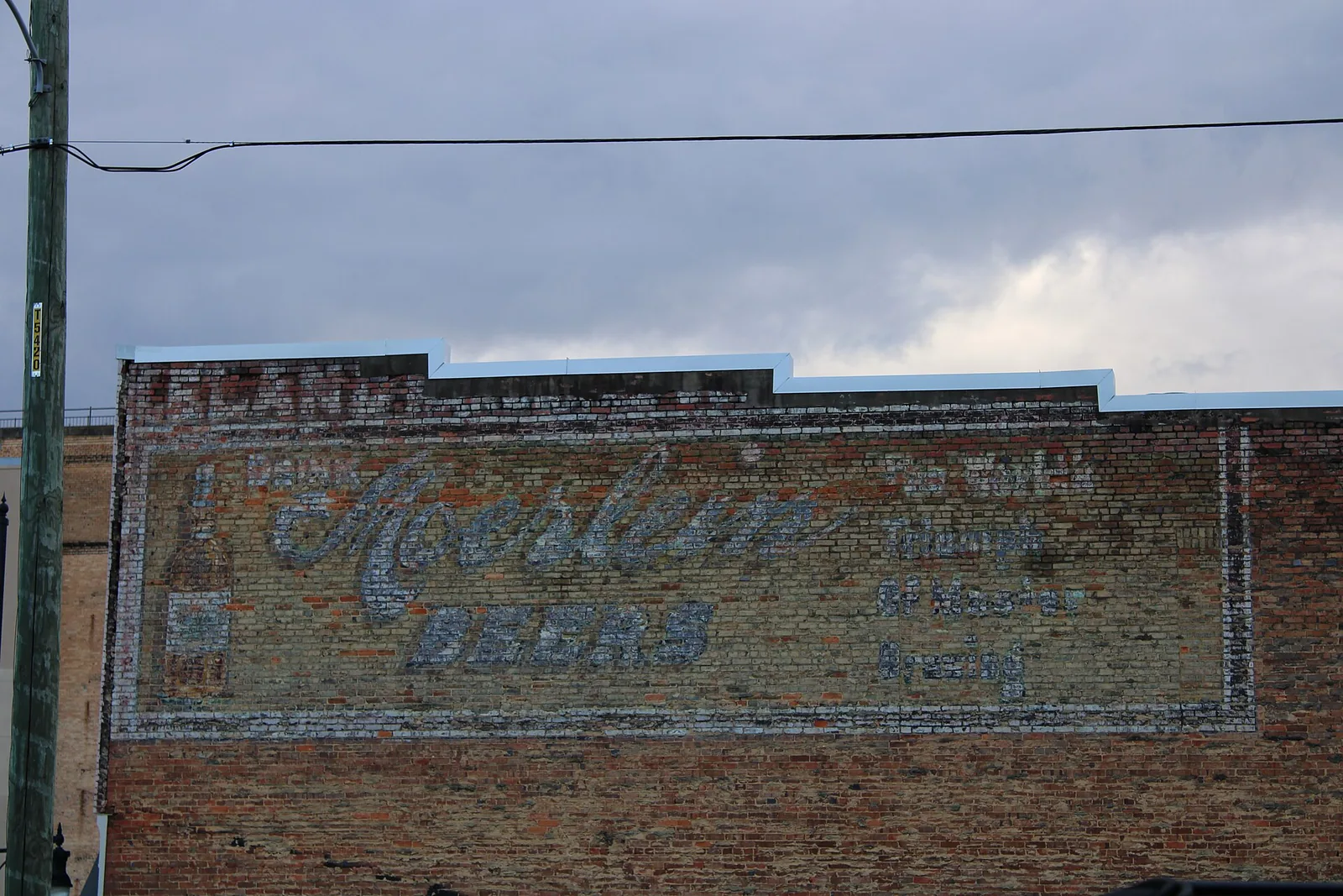 A faded painted beer advertisement on the brick wall of a building in downtown Tuscaloosa.