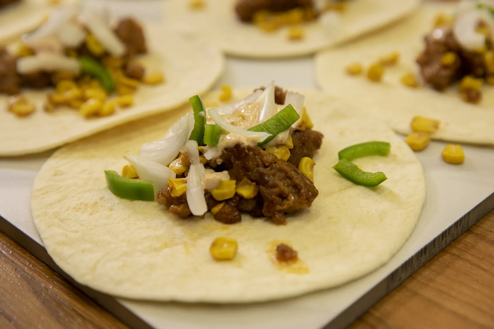 Street corn tacos topped with onion, green pepper and a creamy sauce, photographed by Alabama Extension.