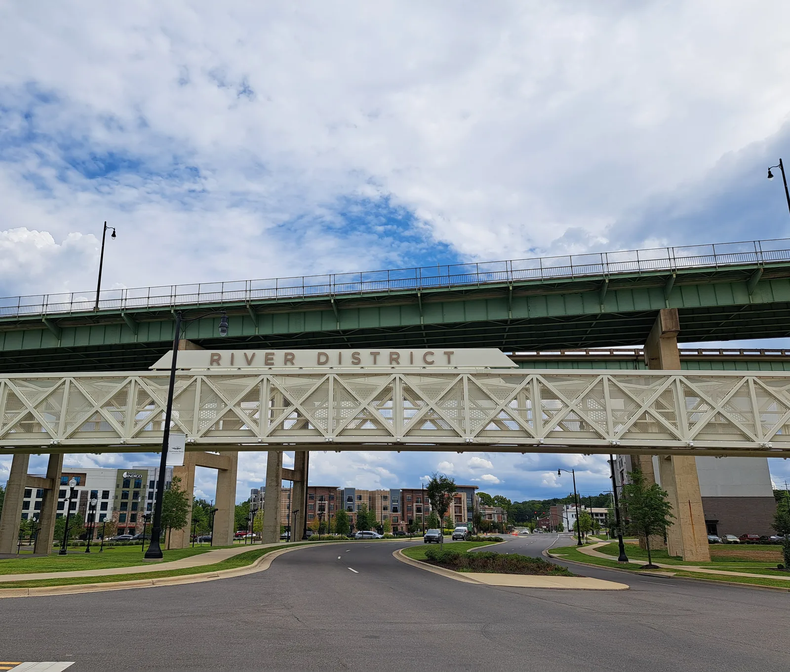 New apartment buildings rise beyond the River District pedestrian bridge and an overpass in Tuscaloosa.