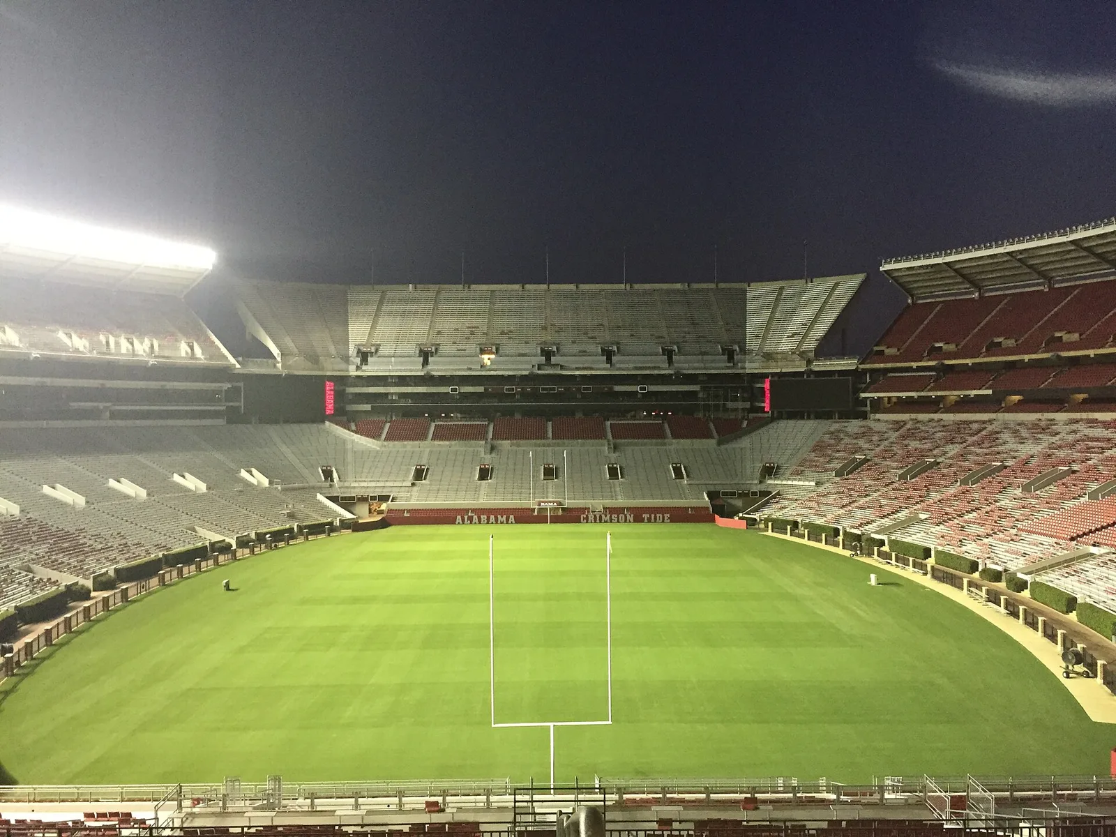 The field and stands of Bryant-Denny Stadium on the University of Alabama campus under the lights.
